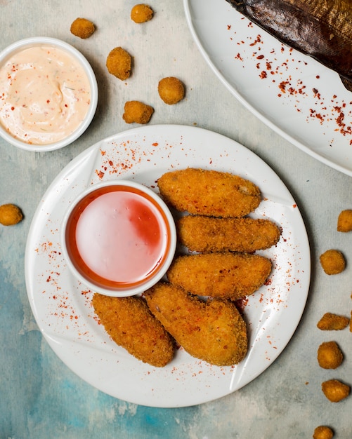 Foto grátis nuggets de frango picantes, servidos com molho de pimenta doce