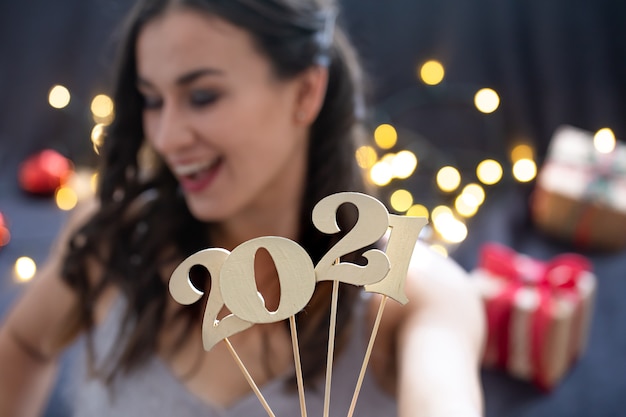 Número de ano novo de madeira no fundo de uma garota de rosto feliz close-up.