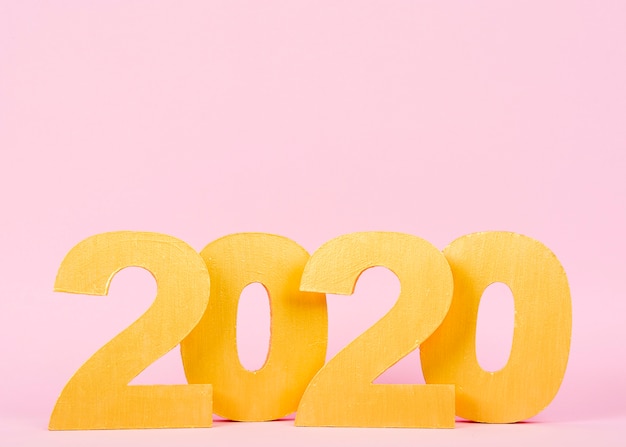 Números do ano novo 2020 em fundo rosa com espaço de cópia