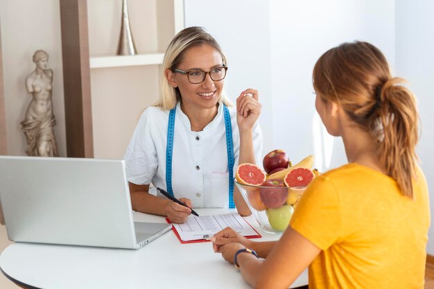 Nutricionista feminina dando consulta ao paciente fazendo plano de dieta na clínica de perda de peso