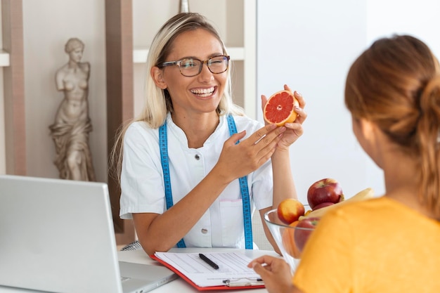 Nutricionista feminina dando consulta ao paciente fazendo plano de dieta na clínica de perda de peso