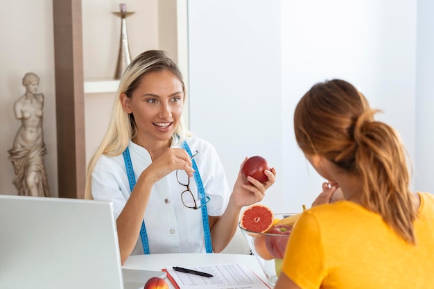Nutricionista feminina dando consulta ao paciente fazendo plano de dieta na clínica de perda de peso