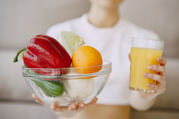 Nutricionista mostrando suco e tigela de legumes