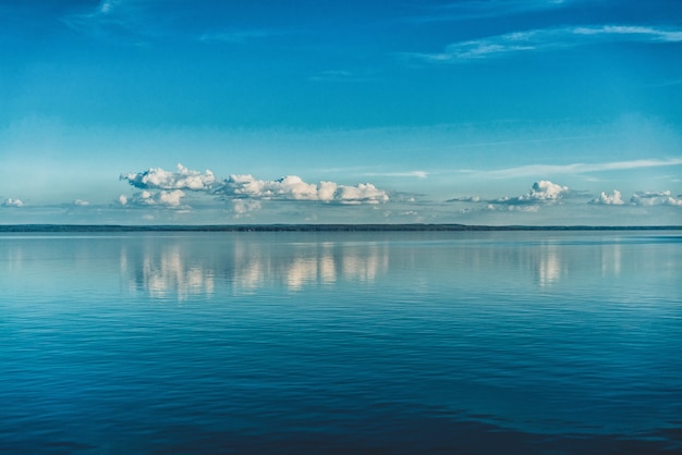 Nuvens brancas puras do céu refletidas na água do mar