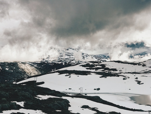 Foto grátis nuvens pesadas sobre as montanhas cobertas de neve