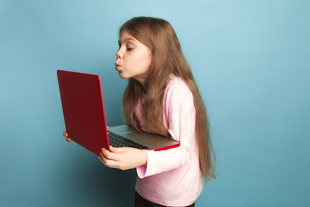 O amor pelo computador. menina adolescente com notebook em um azul.