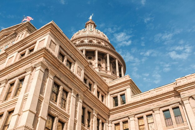 O ângulo baixo disparou da construção de Texas Capitol sob um céu azul bonito. Cidade de Austin, Texas