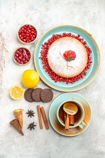 o apetitoso bolo de canela em pau uma xícara de chá e o bolo com framboesas