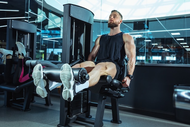 Foto grátis o atleta do sexo masculino treinando duro no ginásio. fitness e conceito de vida saudável.
