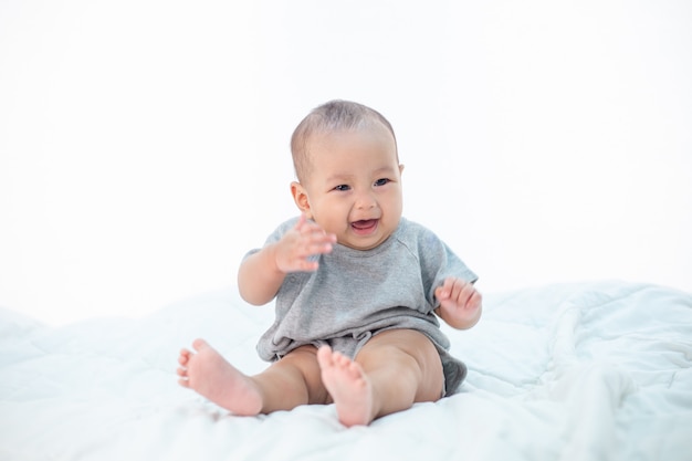 Foto grátis o bebê está feliz na cama.