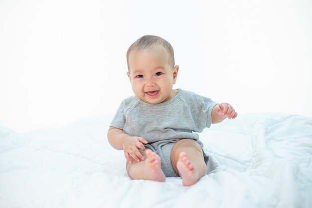 O bebê está feliz na cama.