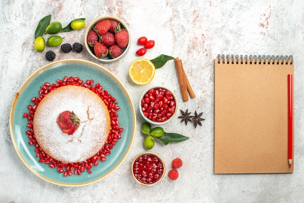 O bolo caderno lápis um bolo com frutas cítricas frutas cítricas canela romã