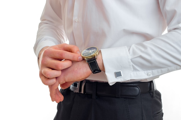 O cara de camisa branca olha para o relógio em um close do braço isolado no fundo branco