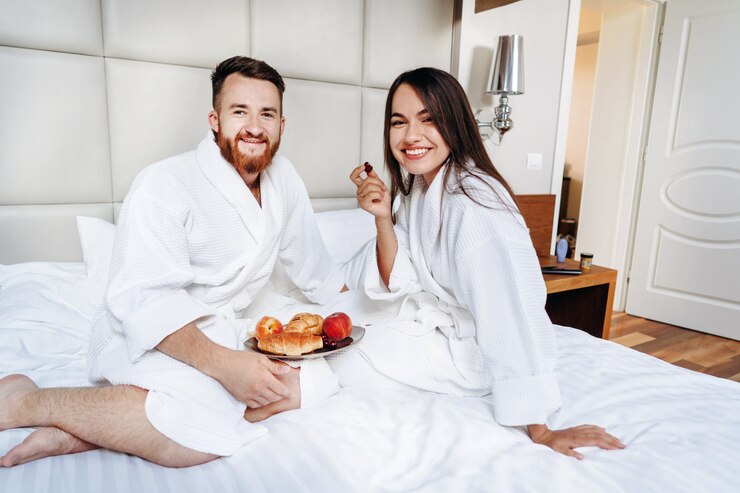 Foto grátis o cara e o roupão da menina, menina alimenta o fruto do cara