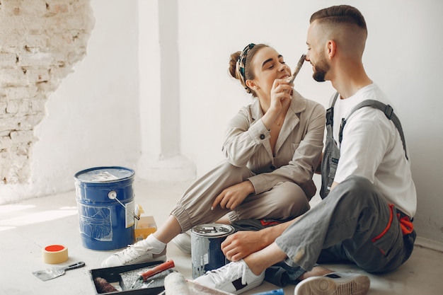 O casal jovem e bonito repara o quarto