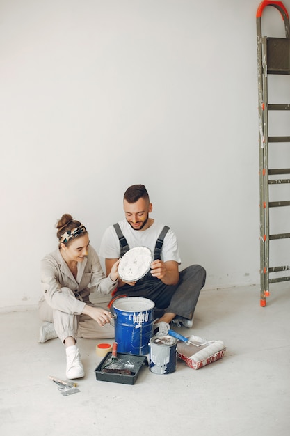 O casal jovem e bonito repara o quarto