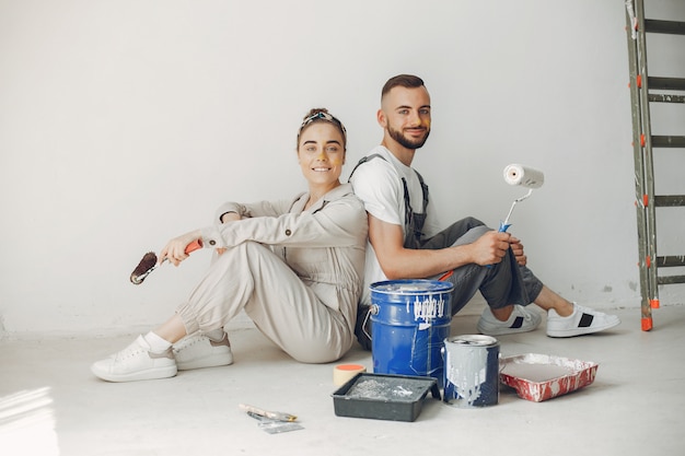 O casal jovem e bonito repara o quarto