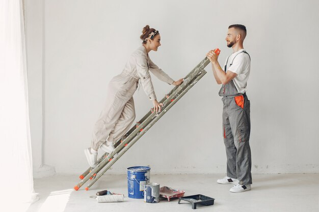 O casal jovem e bonito repara o quarto