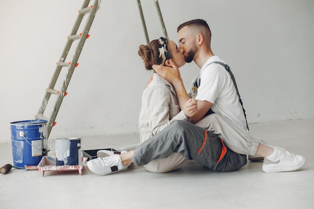 O casal jovem e bonito repara o quarto