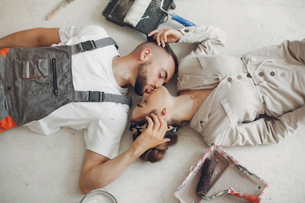 O casal jovem e bonito repara o quarto