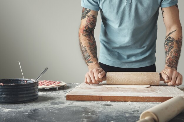 O chefe tatuado cozinha pelmeni, bolinhos ou ravióli em moldes especiais.