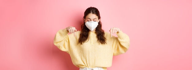 Foto grátis o conceito de cuidados de saúde de medidas preventivas intrigou a mulher no respirador apontando e olhando para baixo