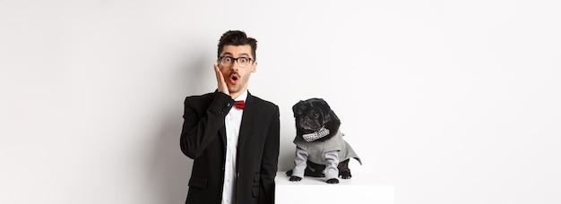 O conceito de festa e celebração de animais chocou o homem bonito em traje formal e cachorro fofo em traje st