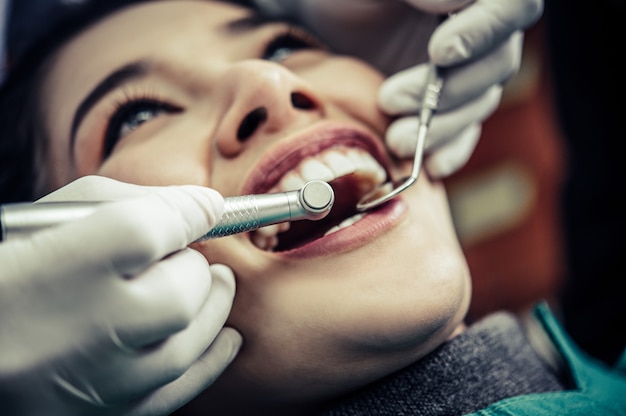 O dentista examina os dentes do paciente.