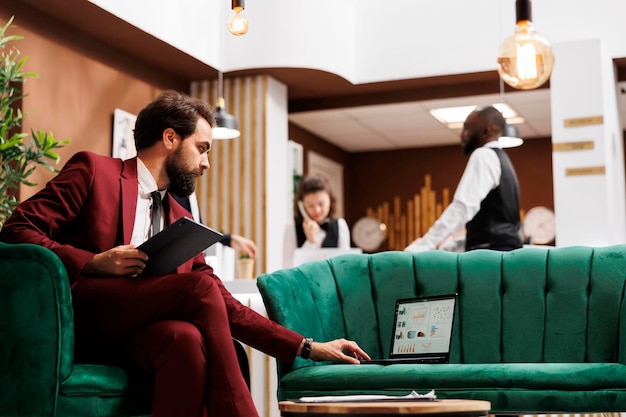 Foto grátis o empreendedor revisa as notas do discurso antes de participar de uma reunião corporativa oficial com outros representantes internacionais. empresário em viagem de trabalho tentando forjar novas alianças, recepção de hotel.