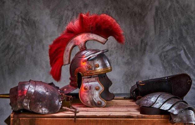 O equipamento de combate completo do antigo guerreiro grego está em uma caixa de tábuas de madeira. Isolado em um fundo escuro.