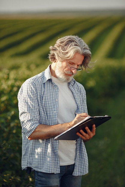 O fazendeiro examina o campo. agrônomo ou fazendeiro examina o crescimento do trigo.