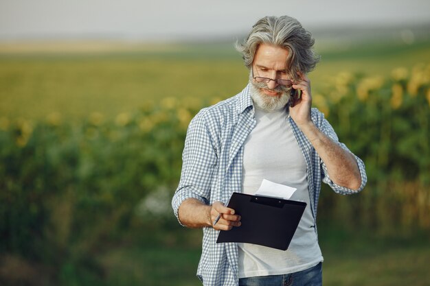 O fazendeiro examina o campo. Agrônomo ou fazendeiro examina o crescimento do trigo.