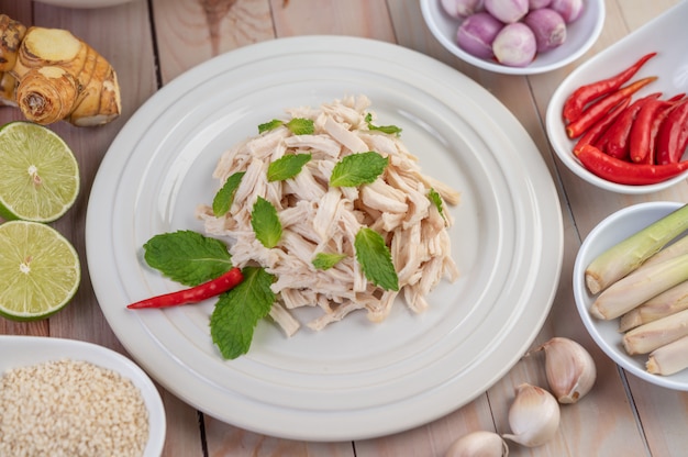 Foto grátis o frango que é cercado é cozido e colocado em um prato branco, juntamente com folhas de hortelã.