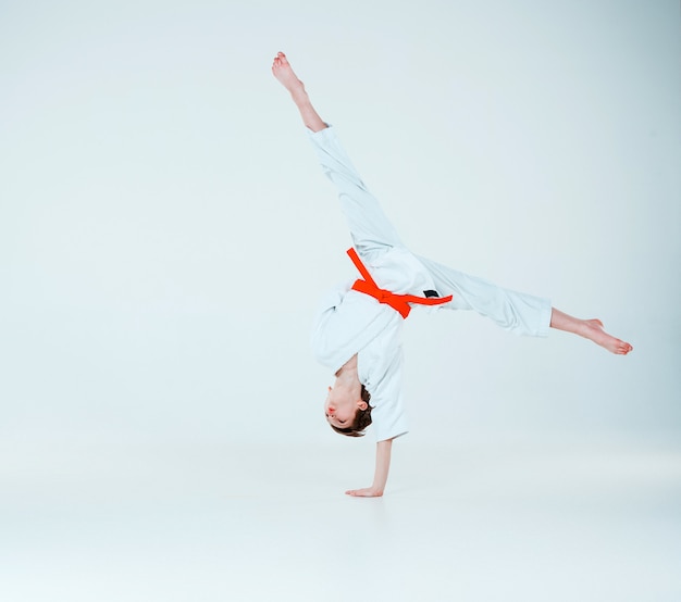 O garoto posando no treinamento de Aikido na escola de artes marciais. Estilo de vida saudável e conceito de esportes