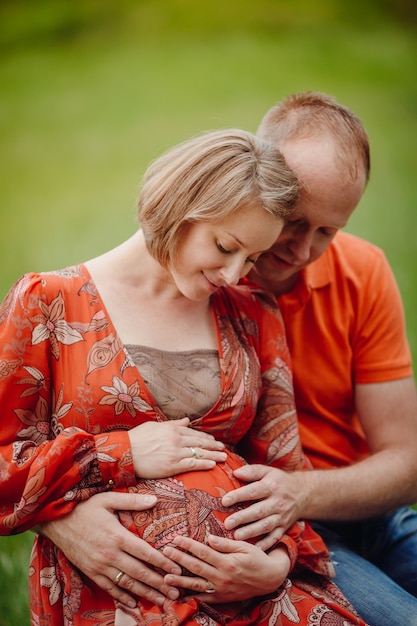 O homem abraça a barriga macia da mulher grávida