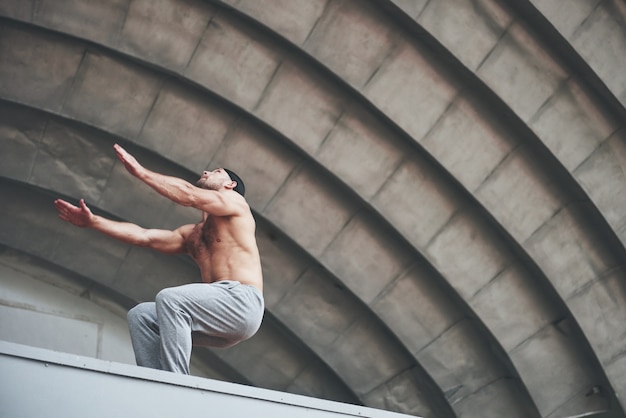 O homem ao ar livre pratica parkour, acrobacias radicais.