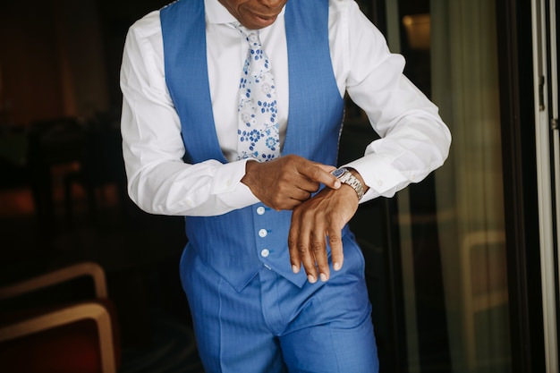 O homem considerável do americano africano no terno azul prepara-se para um casamento