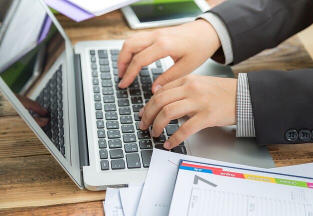 O homem de negócios escrevendo em um laptop