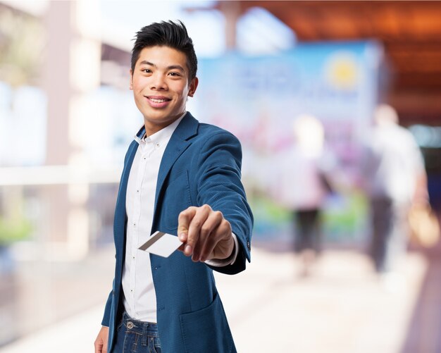 O homem de terno, sorrindo com um cartão de crédito na mão