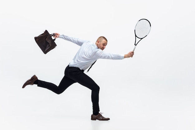 O homem do escritório joga tênis no branco