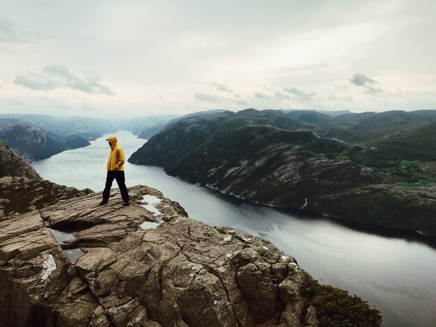 O homem em jaquetas amarelas está perto de uma bela paisagem