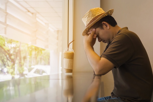 O homem está pensando seriamente ao sentar-se a cafetaria