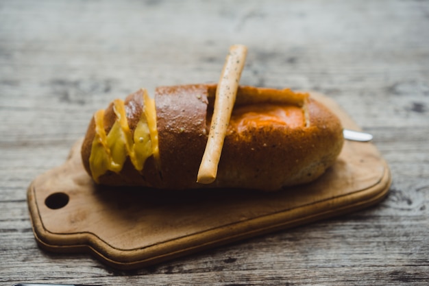 O homem no café tem sopa em um prato de pão.