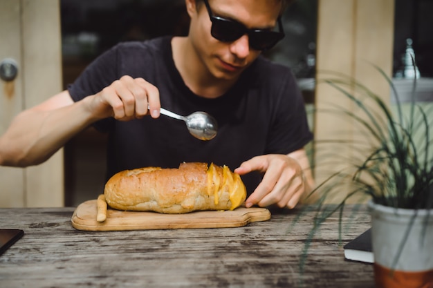 o homem no café tem sopa em um prato de pão.