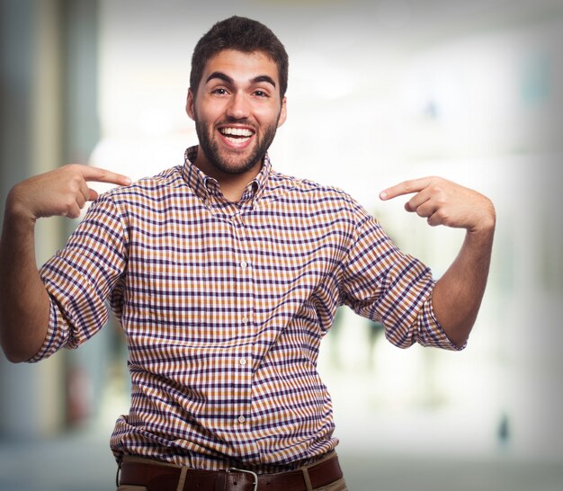 O homem sorrindo e apontando para si mesmo