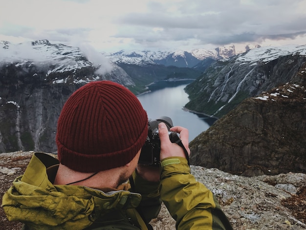 O homem tira uma foto da deslumbrante paisagem escandinava