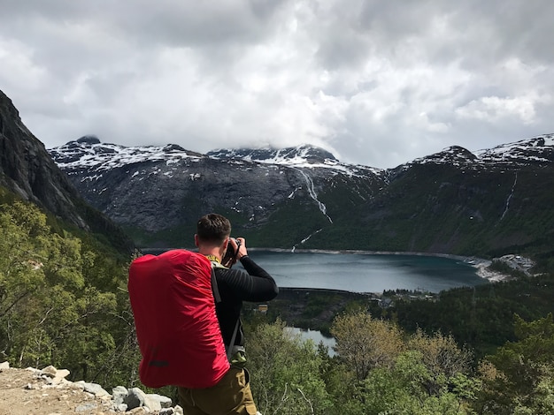 O homem tira uma foto da deslumbrante paisagem escandinava