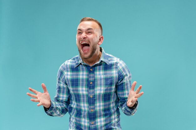 O jovem emocional irritado gritando no espaço