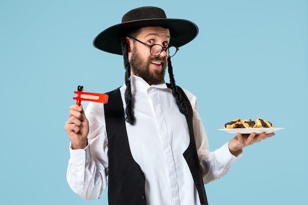 O jovem judeu ortodoxo com biscoitos hamantaschen para o festival de Purim. Feriado, celebração, judaísmo, pastelaria, tradição, biscoito, conceito de religião