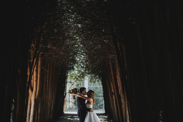 O lindo casal apaixonado se abraçando na floresta